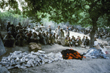 Porters under trees receiving their equipment, Jim Duff, Australia